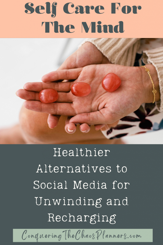 Close-up of hands holding red stones, symbolizing mindfulness and mental well-being. The text overlay says 'Self Care For The Mind' and 'Healthier Alternatives to Social Media for Unwinding and Recharging,' with the website 'ConqueringTheChaosPlanners.com' at the bottom.