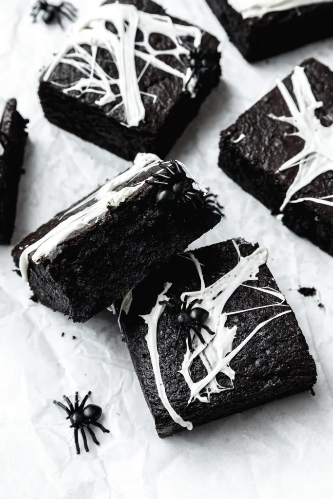 black cocoa brownies with marshmallow spiderweb topping with a little plastic spider as decoration by Barley & Sage
