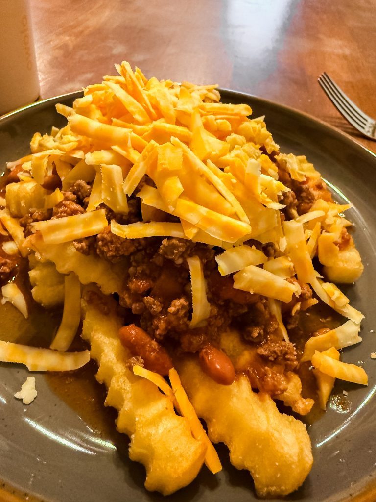 Chili cheese fries topped with shredded cheddar and hearty chili, served as an easy comfort food dinner